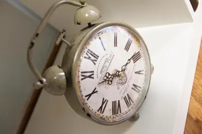 a silver clock hanging on a wall at Athens City Themis 10 in Athens