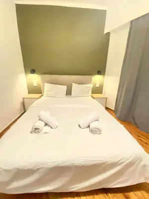a white bed with two towels on top of it at Athens City Themis 10 in Athens