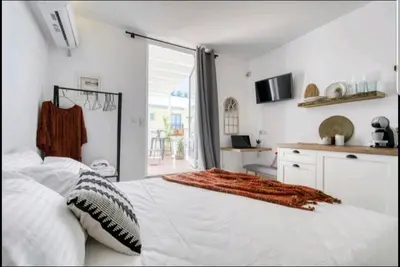 a bedroom with a white bed and a large window at Acropolis stunning view Penthouse in Plaka for 2! in Athens