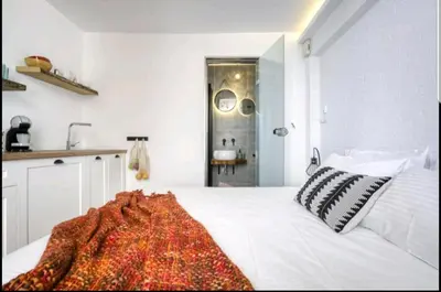 a bedroom with a white bed with a red blanket on it at Acropolis stunning view Penthouse in Plaka for 2! in Athens