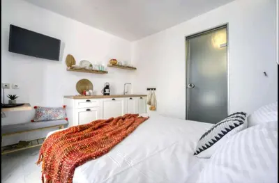 a bedroom with a white bed with a blanket on it at Acropolis stunning view Penthouse in Plaka for 2! in Athens