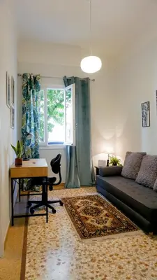 a living room with a couch and a table and a window at Comfortable Apartment in Kallithea by Athenian Homes in Athens