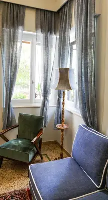 a living room with a chair and a window at A Happy Stay at Edem Beach by Athenian Homes in Athens