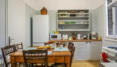 a kitchen with a table and chairs and a kitchen with a refrigerator at A Happy Stay at Edem Beach by Athenian Homes in Athens