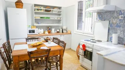 a kitchen with a wooden table and chairs in a kitchen at A Happy Stay at Edem Beach by Athenian Homes in Athens