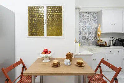 a kitchen with a wooden table with two chairs at A Short Walk to Syntagma and Plaka by Athenian Homes in Athens