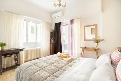 a bedroom with a large bed in a room with windows at A Short Walk to Syntagma and Plaka by Athenian Homes in Athens