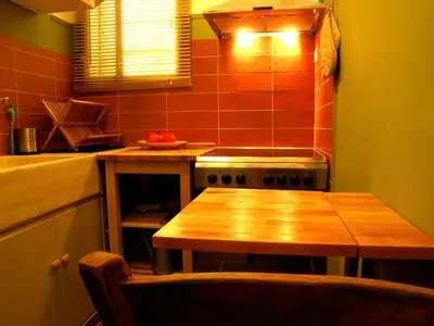 a small kitchen with a wooden table in a kitchen at Homey and calm yet central (by the Hilton) in Athens