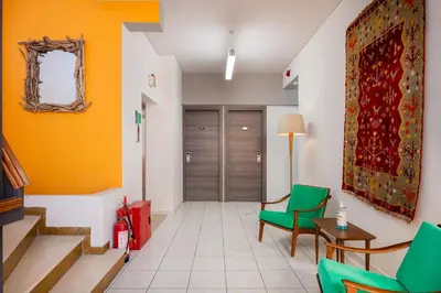 a hallway with green chairs and a door at Diros Hotel in Athens