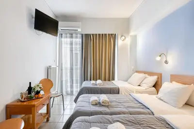 a hotel room with two beds and a television at Diros Hotel in Athens