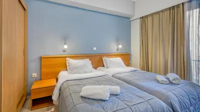 two beds in a hotel room with towels on them at Diros Hotel in Athens