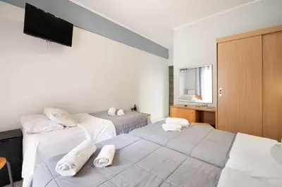 a hotel room with two beds and a television at Diros Hotel in Athens