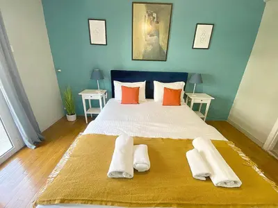 a bedroom with a large bed with orange and white pillows at Check Point - Syngrou Fix in Athens