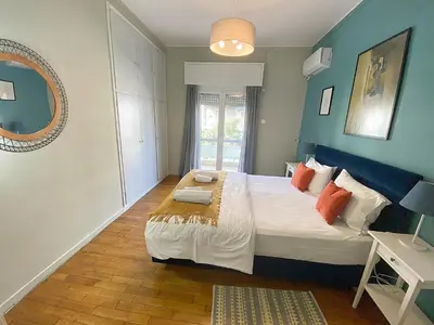 a bedroom with a large bed with blue walls at Check Point - Syngrou Fix in Athens