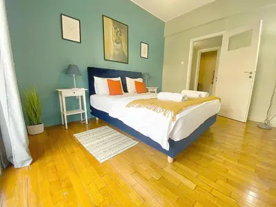 a bedroom with a bed and a wooden floor at Check Point - Syngrou Fix in Athens