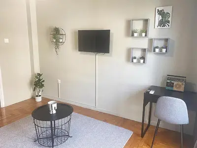 a living room with a table and a tv on the wall at Check Point - Syngrou Fix in Athens
