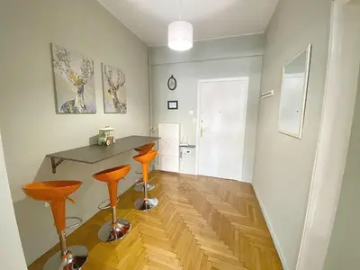 a room with a table and two orange stools at Check Point - Syngrou Fix in Athens