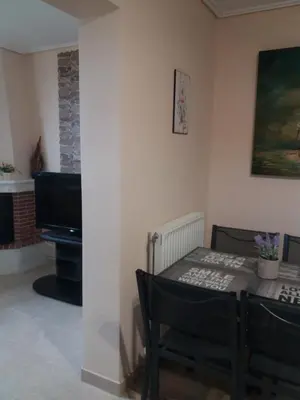 a dining room with a table and a piano at Vaso's country house near the beach and airport in Porto Rafti