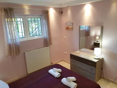 a bathroom with two towels on a bed and a mirror at Vaso's country house near the beach and airport in Porto Rafti