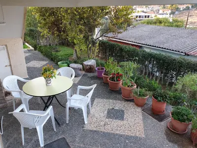 a patio with a table and chairs and potted plants at Vaso's country house near the beach and airport in Porto Rafti