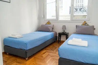 two beds in a room with two windows at Aristotelous Lux Apartment In Athens VIPGreece in Athens