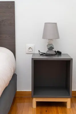 a nightstand with a lamp on it next to a bed at Aristotelous Lux Apartment In Athens VIPGreece in Athens