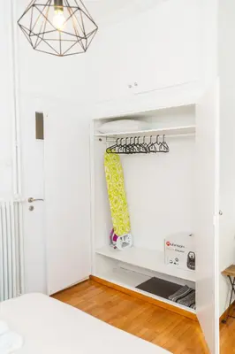 a bedroom with white walls and a bed and a shelf at Aristotelous Lux Apartment In Athens VIPGreece in Athens