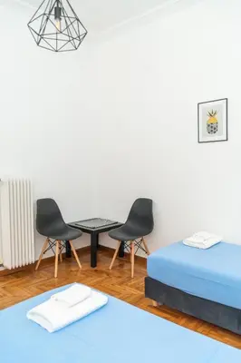 a room with two beds and a table and chairs at Aristotelous Lux Apartment In Athens VIPGreece in Athens