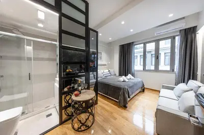 a bedroom with a bed and a bathroom with a tub at The Monastiraki Metro Lux Suite! in Athens