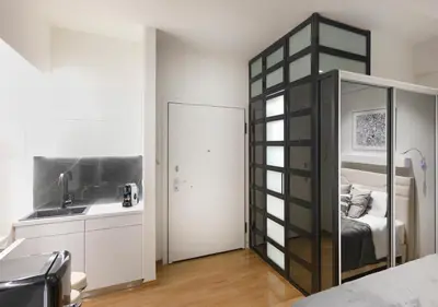 a room with a bed and a kitchen with a mirror at The Monastiraki Metro Lux Suite! in Athens