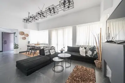 a living room with a black couch and a table at Garden Villa Glyfada in Athens