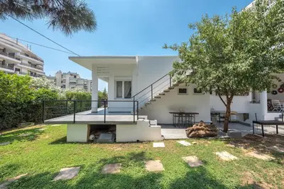 a white house with a staircase and a tree at Garden Villa Glyfada in Athens