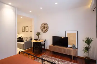 a living room with a television and a table at Phaedrus Living: City Centre Luxury Flat Mavromichali in Athens