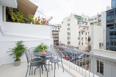 a balcony with a table and chairs on a building at Phaedrus Living: City Centre Luxury Flat Mavromichali in Athens