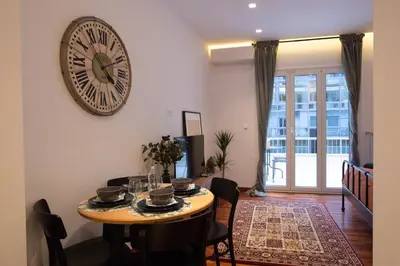 a dining room with a table and a clock on the wall at Phaedrus Living: City Centre Luxury Flat Mavromichali in Athens