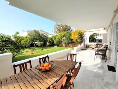 a wooden table with a bowl of fruit on a patio at Luxury Garden Apartment Glyfada in Athens
