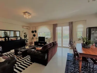 a living room with a couch and a table at Luxury Garden Apartment Glyfada in Athens
