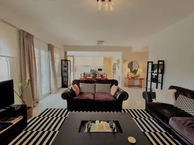 a living room with a couch and a table at Luxury Garden Apartment Glyfada in Athens