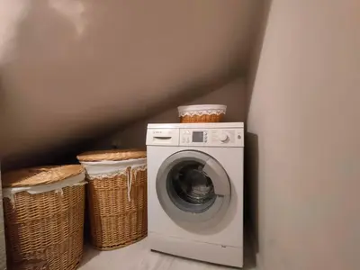 a washing machine in a corner with two baskets at Luxury Garden Apartment Glyfada in Athens