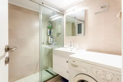 a bathroom with a shower and a sink and a washing machine at Athens Perfect Spot - Zografou Cozy Home in Athens