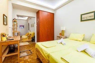 a small room with two beds and a desk and a desk at Athens Perfect Spot - Zografou Cozy Home in Athens
