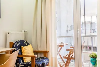a living room with a chair and a window at Athens Perfect Spot - Zografou Cozy Home in Athens