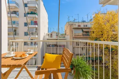a balcony with a wooden table and chairs at Athens Perfect Spot - Zografou Cozy Home in Athens