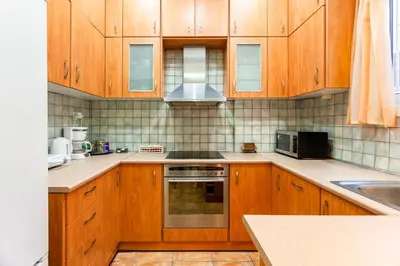a kitchen with wooden cabinets and a stove top oven at Athens Perfect Spot - Zografou Cozy Home in Athens