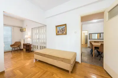 a living room with a bed and a dining room at Victoria Plaza Palace Apartments in Athens