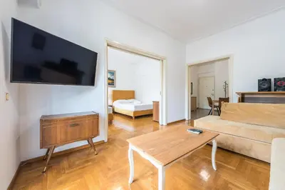 a living room with a couch and a tv on a wall at Victoria Plaza Palace Apartments in Athens