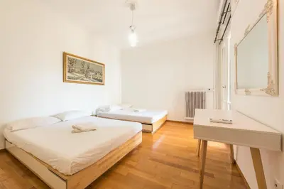a white room with two beds and a desk at Victoria Plaza Palace Apartments in Athens