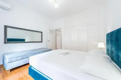 a bedroom with two beds and a mirror on the wall at Victoria Queens Suites Apartments in Athens