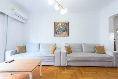 a living room with a couch and a table at Victoria Queens Suites Apartments in Athens
