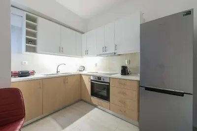 a kitchen with white cabinets and a refrigerator at Victoria Queens Suites Apartments in Athens